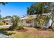 Inviting one-story home featuring a well-kept lawn, lush tropical landscaping, and white picket fence at 2623 Parsley Dr, Orlando, FL 32837