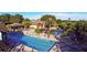 Aerial view of a community pool with pergolas, lounge chairs, and lush green landscaping at 26712 Augusta Springs Cir, Leesburg, FL 34748