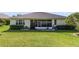 A well maintained backyard featuring lush green grass and a screened-in patio at 26712 Augusta Springs Cir, Leesburg, FL 34748