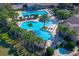 Aerial view showcases a stunning community pool with a lagoon-style design, palm trees, and a relaxing spa at 26712 Augusta Springs Cir, Leesburg, FL 34748