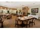 A neutral colored dining room with tables set for service and a large stone fireplace at 26712 Augusta Springs Cir, Leesburg, FL 34748