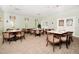 An empty dining room with beige walls, neutral carpet, and formal table settings at 26712 Augusta Springs Cir, Leesburg, FL 34748