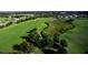 Scenic aerial view of the golf course and pond surrounded by lush greenery and beautiful landscaping at 26712 Augusta Springs Cir, Leesburg, FL 34748