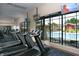 Well-equipped gym featuring modern treadmills, large windows overlooking the pool area, and mounted TV screens at 26712 Augusta Springs Cir, Leesburg, FL 34748