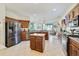 Spacious kitchen featuring stainless steel appliances, center island, tile flooring, and wood cabinets at 26712 Augusta Springs Cir, Leesburg, FL 34748