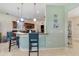 Kitchen with breakfast bar seating, wood cabinets, pendant lighting, and tiled floor at 26712 Augusta Springs Cir, Leesburg, FL 34748