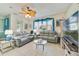 Bright living room with neutral tones, fan, tile flooring, comfortable seating, and natural light at 26712 Augusta Springs Cir, Leesburg, FL 34748