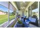 Inviting screened-in patio with comfortable seating and a view of the landscaped backyard at 26712 Augusta Springs Cir, Leesburg, FL 34748