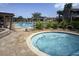 Relaxing community pool area with hot tub, pergola, and lush tropical landscaping on a sunny day at 26712 Augusta Springs Cir, Leesburg, FL 34748