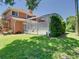 Beautiful backyard with green grass, mature trees, and a screened lanai at 3020 Zaharias Dr, Orlando, FL 32837