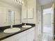 Bathroom featuring dual sinks, a large mirror, and a doorway leading into a bedroom at 3020 Zaharias Dr, Orlando, FL 32837