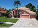 Lovely home featuring a tile roof, well-kept landscaping, a three-car garage, and a mature palm tree at 3020 Zaharias Dr, Orlando, FL 32837