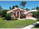 Charming home featuring a tile roof, manicured lawn, lush landscaping, and a three-car garage at 3020 Zaharias Dr, Orlando, FL 32837