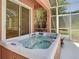An enclosed hot tub and covered patio overlooking tropical landscaping at 3020 Zaharias Dr, Orlando, FL 32837