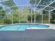 Screened pool area with clear blue water surrounded by lush greenery at 3020 Zaharias Dr, Orlando, FL 32837