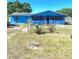 Charming blue single-story home with a screened-in porch and fenced yard under a bright blue sky at 311 E Bridgers Ave, Auburndale, FL 33823