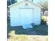 Image shows an exterior view of a white outbuilding featuring a simple door and a small ramp leading to the entrance at 311 E Bridgers Ave, Auburndale, FL 33823