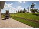 Beautiful outdoor patio features a brick fireplace and a well-manicured lawn, perfect for entertaining and relaxing at 3289 Songbird Cir, Harmony, FL 34773