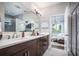 Modern bathroom with double sinks, quartz counters, and a separate shower room at 3289 Songbird Cir, Harmony, FL 34773