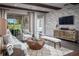 Modern living room showcasing stone accent wall, sliding glass doors, and stylish decor at 3289 Songbird Cir, Harmony, FL 34773