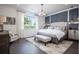 Stylish main bedroom with a large window, decorative wall, and elegant furnishings at 3289 Songbird Cir, Harmony, FL 34773