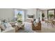 Bright living room featuring a comfortable sofa, woven chair, area rug and entertainment center with a large window at 33640 Seattle Slew Dr, Sorrento, FL 32776