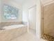Bathroom with a tub with tile surround next to a glass shower with a stone floor at 341 Bahia Cir, Longwood, FL 32750