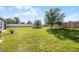Large, grassy backyard featuring mature trees, a stone perimeter fence, and plenty of room for activities at 3753 Apopka Ridge Cir, Apopka, FL 32703