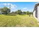 Open backyard features a stone perimeter fence, a well-maintained lawn, and mature shade trees at 3753 Apopka Ridge Cir, Apopka, FL 32703