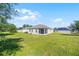 Rear exterior view of house showing a screened porch and large grassy backyard with perimeter fencing at 3753 Apopka Ridge Cir, Apopka, FL 32703