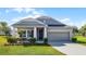 Charming single-Gathering home features a well-manicured lawn and a two-car garage with a gray color scheme at 3753 Apopka Ridge Cir, Apopka, FL 32703