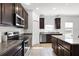 Modern kitchen with granite countertops, stainless steel appliances, and dark wood cabinetry, creating a gourmet space at 3753 Apopka Ridge Cir, Apopka, FL 32703