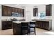 Bright kitchen features a granite island, dark wood cabinets and stainless steel appliances at 3753 Apopka Ridge Cir, Apopka, FL 32703