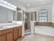 Bathroom with vanity, tiled shower and soaking tub near window at 3908 Coastal Breeze Dr, Kissimmee, FL 34744