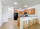 Functional kitchen with wood cabinets, breakfast bar, and black appliances at 3908 Coastal Breeze Dr, Kissimmee, FL 34744