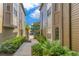 Exterior of the tan townhouse with lush landscaping and a sidewalk leading to the street at 420 Summit Ridge Pl # 112, Longwood, FL 32779
