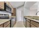 Modern kitchen featuring stainless steel appliances, granite countertops and tan cabinetry at 420 Summit Ridge Pl # 112, Longwood, FL 32779