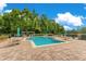 Community pool with tables, chairs, umbrellas, and lush landscaping at 420 Summit Ridge Pl # 112, Longwood, FL 32779