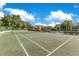View of community tennis court surrounded by lush landscaping and parking at 420 Summit Ridge Pl # 112, Longwood, FL 32779