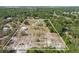 Aerial view highlights the home and acreage, showcasing its mature trees and detached garage on a spacious homesite at 4232 Spring Ln, Lakeland, FL 33811