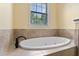 Relaxing bathroom featuring a soaking tub with tile surround and a window view at 4232 Spring Ln, Lakeland, FL 33811