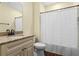 Bathroom with vanity, sink, and tile flooring, featuring a tub with a decorative shower curtain at 4232 Spring Ln, Lakeland, FL 33811