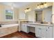 Bright bathroom with a soaking tub, double vanity, and granite countertops at 4232 Spring Ln, Lakeland, FL 33811