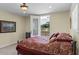 Bedroom with neutral carpet and door to the outside, featuring a queen bed with red patterned bedding at 4232 Spring Ln, Lakeland, FL 33811