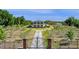 View of a beautiful home with a circular driveway, surrounded by trees and greenery, captured behind an ornate metal gate at 4232 Spring Ln, Lakeland, FL 33811
