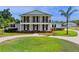 Stunning two-story home with a beautiful lawn and a circular driveway framed by classic columns and a balcony at 4232 Spring Ln, Lakeland, FL 33811