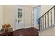 The well-lit foyer features hardwood floors, a white door with glass inserts, and a staircase with black wrought iron at 4232 Spring Ln, Lakeland, FL 33811