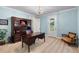 Well-lit office space featuring a wooden desk, hutch, comfortable seating, and natural light from the door at 4232 Spring Ln, Lakeland, FL 33811