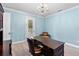 Bright office space featuring a large wooden desk, a comfortable chair, and a chandelier at 4232 Spring Ln, Lakeland, FL 33811