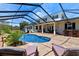 Backyard pool featuring screen enclosure, stone accents and lush landscaping at 4232 Spring Ln, Lakeland, FL 33811